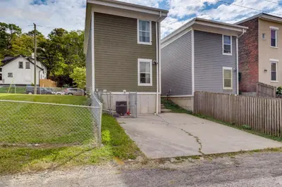 a house with a fence in front of it at Walk to UC and Hospitals! Cincy Home with Patio in Cincinnati