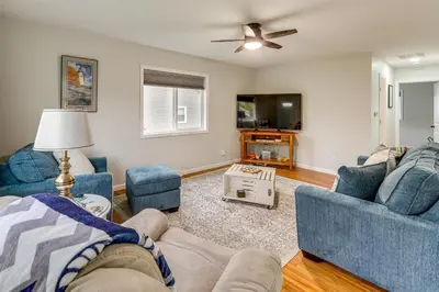 a living room with blue couches and a tv at Walk to Lagoon Saloon! Chic Home on Nugents Canal in Port Clinton