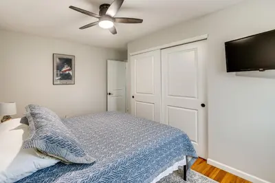 a bedroom with a bed and a ceiling fan at Walk to Lagoon Saloon! Chic Home on Nugents Canal in Port Clinton