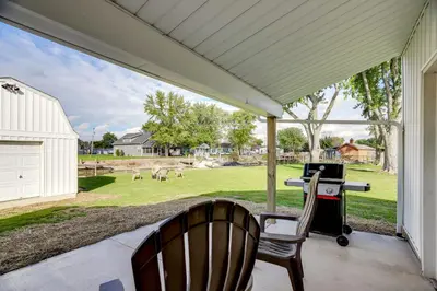 a screened in porch with a grill and a chair at Walk to Lagoon Saloon! Chic Home on Nugents Canal in Port Clinton