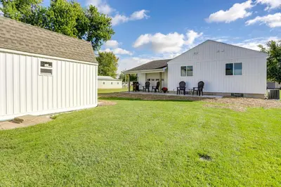 a white building with chairs and a yard at Walk to Lagoon Saloon! Chic Home on Nugents Canal in Port Clinton
