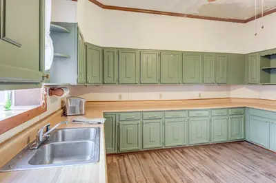a kitchen with green cabinets and a sink at 2 Blocks to Ohio River! Historic Victorian Gem in Gallipolis
