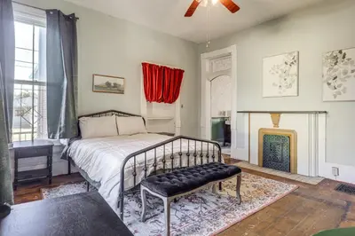 a bedroom with a bed and a fireplace at 2 Blocks to Ohio River! Historic Victorian Gem in Gallipolis