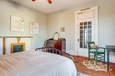 a bedroom with a bed and a chair and a clock at 2 Blocks to Ohio River! Historic Victorian Gem in Gallipolis