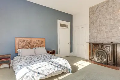 a bedroom with a bed and a fireplace at 2 Blocks to Ohio River! Historic Victorian Gem in Gallipolis