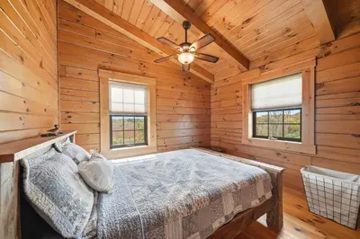 a bedroom with a bed in a log cabin at Sprinkle Bottom Lodge- 12 Acre Cabin, Pond, AC, Heating & Pet Friendly
