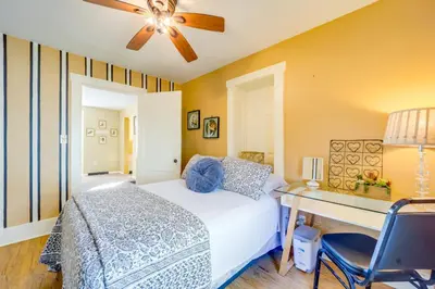a bedroom with a bed and a desk and a ceiling fan at 10 Mi to Mad River Mtn Family-Friendly Retreat! in West Liberty