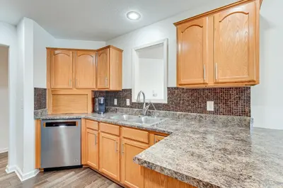 a kitchen with wooden cabinets and a sink at Private Yard and Pond Views Fort Wayne Family Home! in Fort Wayne