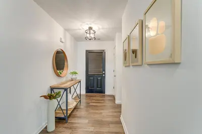 a hallway with a blue door and a table at Private Yard and Pond Views Fort Wayne Family Home! in Fort Wayne