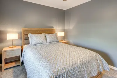 a bedroom with a bed and two lamps on tables at Private Yard and Pond Views Fort Wayne Family Home! in Fort Wayne