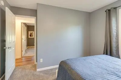 a bedroom with a blue bed and a hallway at Private Yard and Pond Views Fort Wayne Family Home! in Fort Wayne