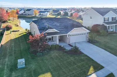 an aerial view of a house with a driveway at Private Yard and Pond Views Fort Wayne Family Home! in Fort Wayne
