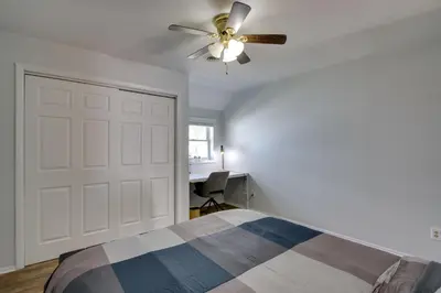 a bedroom with a ceiling fan and a white door at Peaceful Country Apt Extended Stays Welcome! in Pataskala