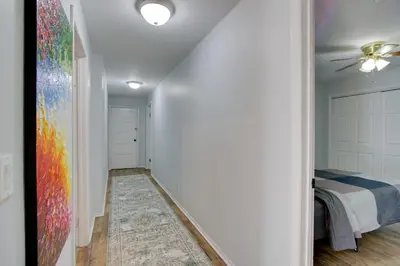 a hallway with a bedroom with a bed and a rug at Peaceful Country Apt Extended Stays Welcome! in Pataskala