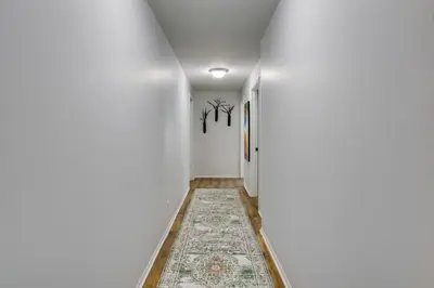 a hallway with white walls and a rug on the floor at Peaceful Country Apt Extended Stays Welcome! in Pataskala