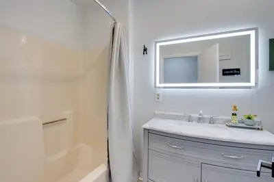 a bathroom with a sink and a mirror and a tub at Peaceful Country Apt Extended Stays Welcome! in Pataskala