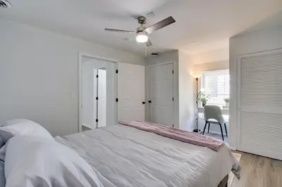 a white bedroom with a bed and a chair at 21 Mi to Dtwn Columbus Quiet Country Escape in Pataskala