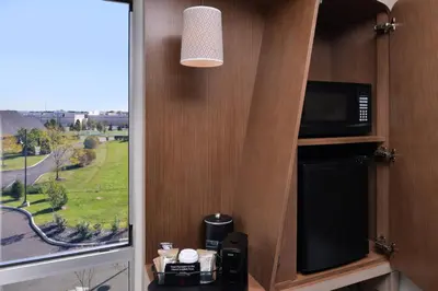 a kitchen with a microwave and a tv and a window at Courtyard by Marriott Columbus Grove City in Grove City
