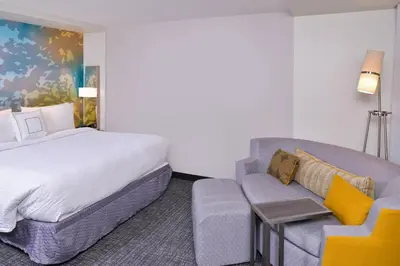 a hotel room with a bed and a couch at Courtyard by Marriott Columbus Grove City in Grove City