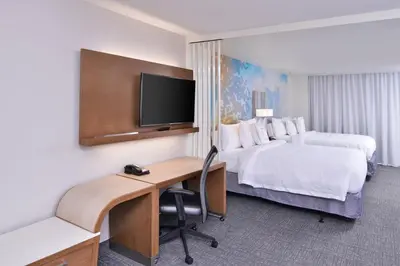 a hotel room with two beds and a desk and a tv at Courtyard by Marriott Columbus Grove City in Grove City