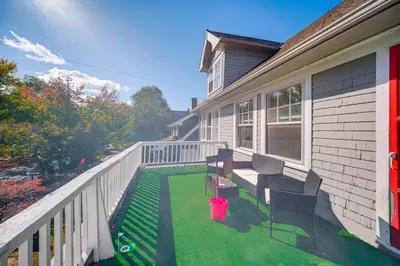 a porch of a house with chairs on the grass at Deck, Pool Table! Walkable Cleveland Heights Apt in Cleveland Heights