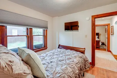 a bedroom with a bed and a large window at 1 Mi to Akron Zoo Ranch-Style Home with Yard! in Akron
