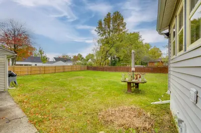 a backyard with a table in the grass at 1 Mi to Akron Zoo Ranch-Style Home with Yard! in Akron