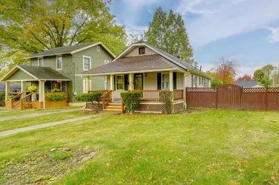a house with a fence in front of a yard at 1 Mi to Akron Zoo Ranch-Style Home with Yard! in Akron