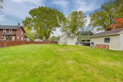 a yard with a house and a fence at 1 Mi to Akron Zoo Ranch-Style Home with Yard! in Akron