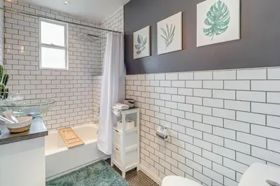 a bathroom with white subway tiles and a sink at Pet-Friendly Oakley Gem with Large Backyard! in Cincinnati