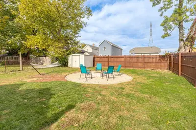 a backyard with chairs and a table and a fence at Pet-Friendly Oakley Gem with Large Backyard! in Cincinnati