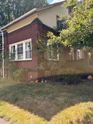 a red brick house with a yard in front of it at Tree House 6 bedrooms, 2 blocks from everything in Cuyahoga Falls