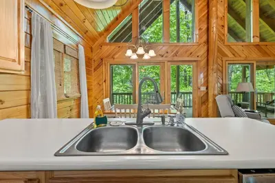 a kitchen with a sink in a log cabin at Hot Tub & WiFi - Birdsong - Red River Gorge KY in Stanton