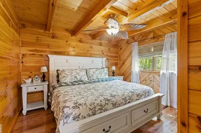 a bedroom with a bed in a log cabin at Hot Tub & WiFi - Birdsong - Red River Gorge KY in Stanton
