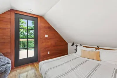 a attic bedroom with a bed and a window at Hot Tub - Furnace Mountain Retreat - #RRG in Stanton