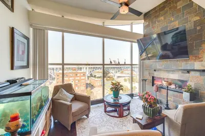 a living room with a fish tank and a large window at 3 Mi to Dtwn Cleveland Condo with Lake Erie Views! in Cleveland