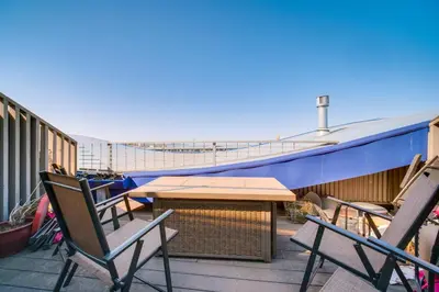 a balcony with chairs and a table and a boat at 3 Mi to Dtwn Cleveland Condo with Lake Erie Views! in Cleveland