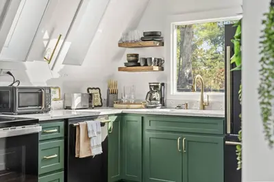a kitchen with green cabinets and a window at Hot-Tub Sauna Cold Plunge - Evergreen Escape in Campton
