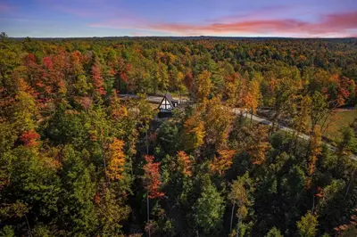 an autumn view of a cabin in the woods at Hot-Tub Sauna Cold Plunge - Evergreen Escape in Campton