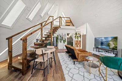 a living room with a staircase and a couch at Hot-Tub Sauna Cold Plunge - Evergreen Escape in Campton