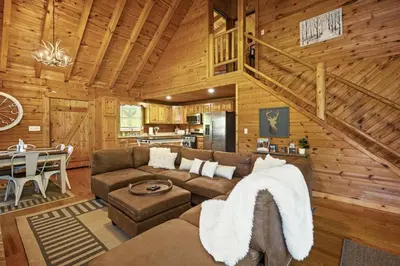 a living room with a couch and a table at Hot Tub WiFi Firepit HazelBrook Haven in Hazel Green