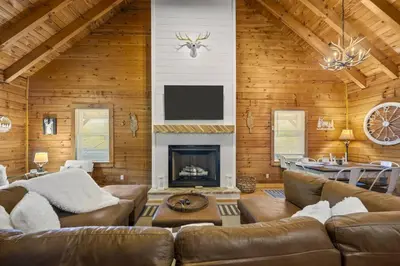 a living room with a couch and a fireplace at Hot Tub WiFi Firepit HazelBrook Haven in Hazel Green