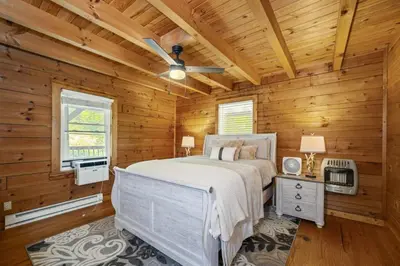 a bedroom with a bed and a ceiling fan at Hot Tub WiFi Firepit HazelBrook Haven in Hazel Green