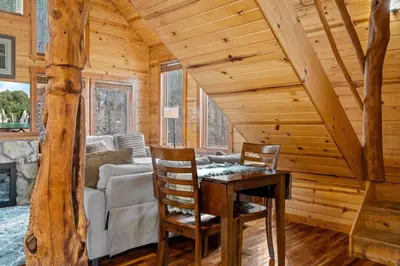 a dining room with a table and chairs in a log cabin at Hot Tub No Pet Fee Prime Location - Beary Cozy in Slade