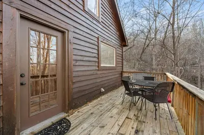 a wooden deck with a table and chairs on a house at Hot Tub No Pet Fee Prime Location - Beary Cozy in Slade