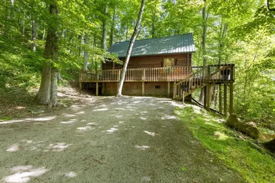 a log cabin in the woods with a bridge and a house at Hot Tub No Pet Fee - Beary Secluded - RRG in Slade