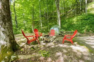 three red chairs and a picnic table in the woods at Hot Tub No Pet Fee - Beary Secluded - RRG in Slade
