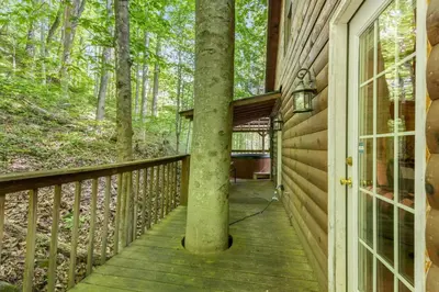 a wooden porch with a tree on the side of a house at Hot Tub No Pet Fee - Beary Secluded - RRG in Slade