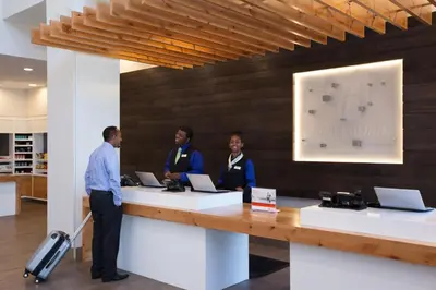 a man and two women standing at a counter at Holiday Inn Cleveland Clinic by IHG in Cleveland