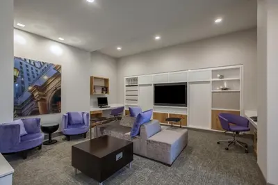 a living room with a couch and blue chairs at Holiday Inn Cleveland Clinic by IHG in Cleveland